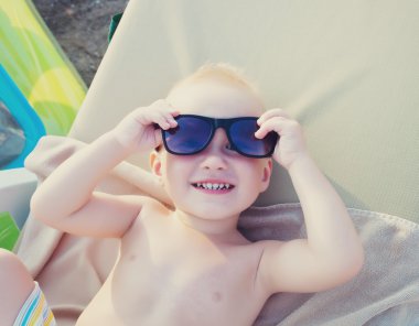 Sahilde gözlüklü boy gülümseyerek