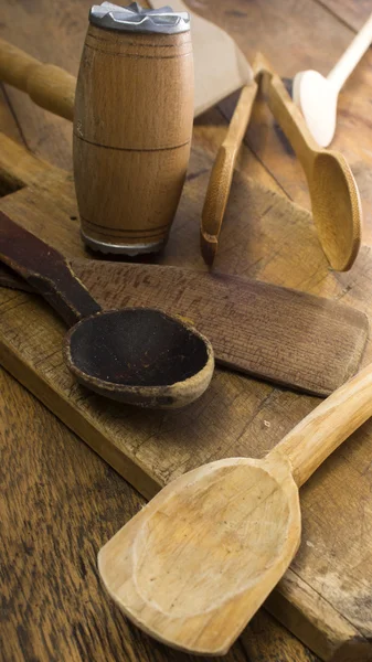 Utensílios de cozinha de madeira sobre mesa de madeira e tábua de corte . — Fotografia de Stock