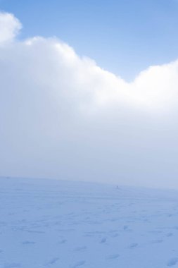 Karlı yamaçlar bulutlarla kaplı.