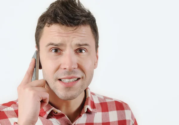 Surprised man talking on his mobile phone and looking at camera — Stock Photo, Image