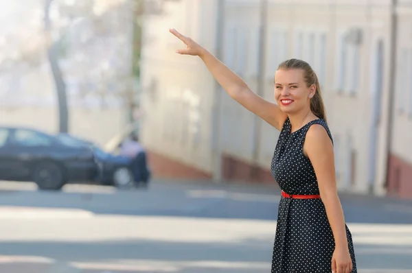 A gorgeous woman hailing a cab after a long day of clothes shopp — Stock Photo, Image