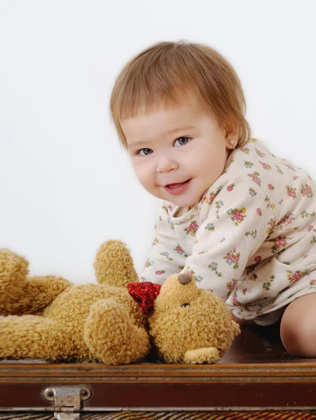 Funny little girl playing on a suitcase — Stock Photo, Image