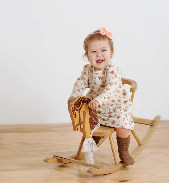 Happy little girl and horse - rocking chair — Stock Photo, Image