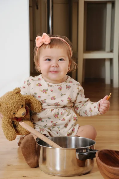 Petite fille cuisine avec ours en peluche — Photo