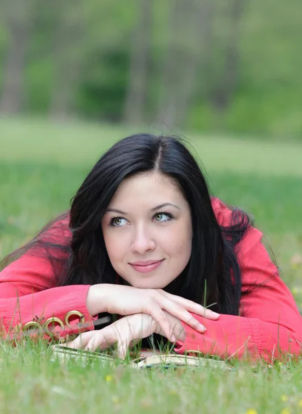 Portrait de jeune femme ayant un repos avec livre sur l'herbe dans le — Photo
