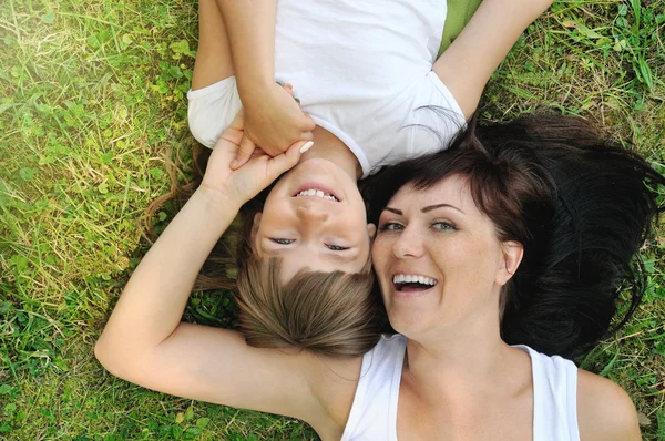 Портрет счастливой девушки и ее матери, развлекающейся на траве — стоковое фото