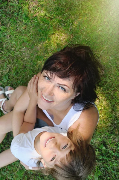 Семейный портрет счастливой девочки и ее матери, веселящейся на г — стоковое фото