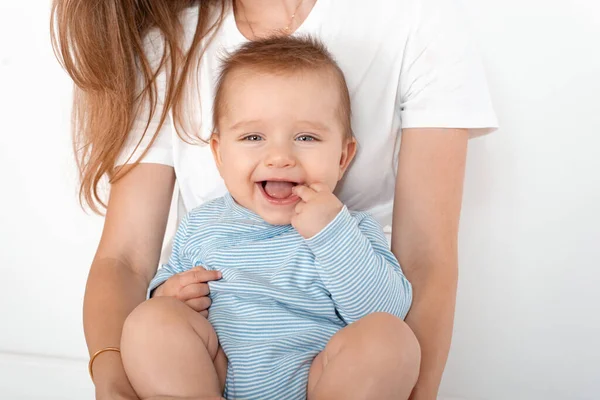 白い背景に美しい青い目のかわいい幸せな赤ちゃんの男の子を保持するお母さん 幸せな子供時代と母親の概念 — ストック写真