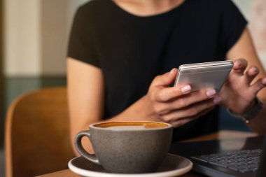 Kafenin içinde akıllı telefon ve dizüstü bilgisayarın yakın plan çekimi, internet mesafesinde. Serbest çalışma kavramı