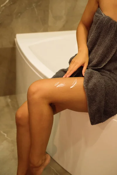 化粧クリームで女の足を撃つ スキンケア製品 女は体の肌を潤す 美人スパのコンセプト — ストック写真