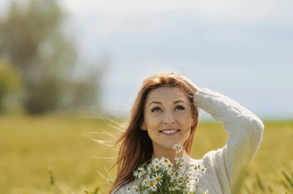 Hermosa mujer sonriente en el campo de otoño soleado con ramo de camuflaje —  Fotos de Stock