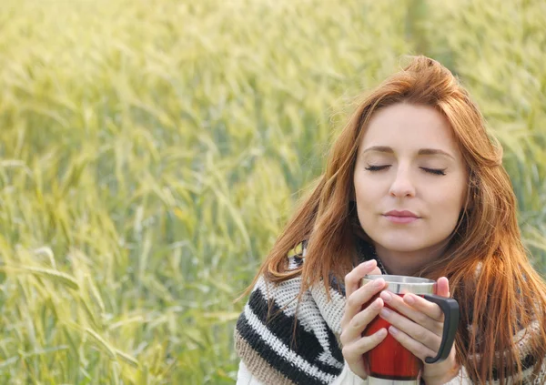 Beautiful woman enjoying hot drink in autumn cold day — Stock Photo, Image