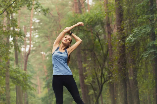 Gezonde levensstijl fitness sportieve vrouw die zich uitstrekt voordat run in — Stockfoto