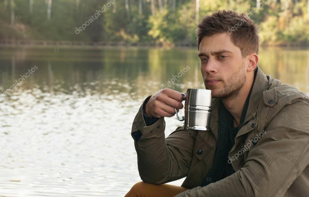 handsome attractive man at the lake on beautiful nature backgrou