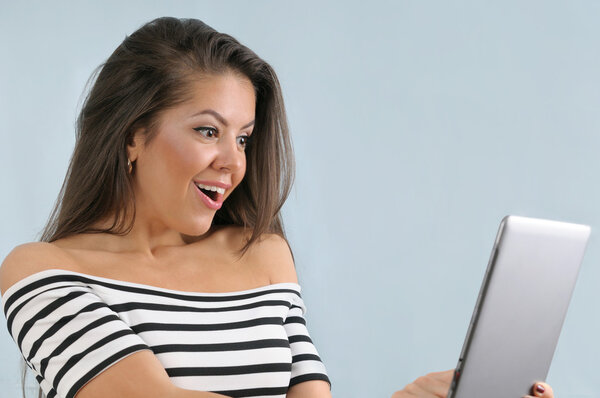Attractive cute happy young emotional woman using tablet device