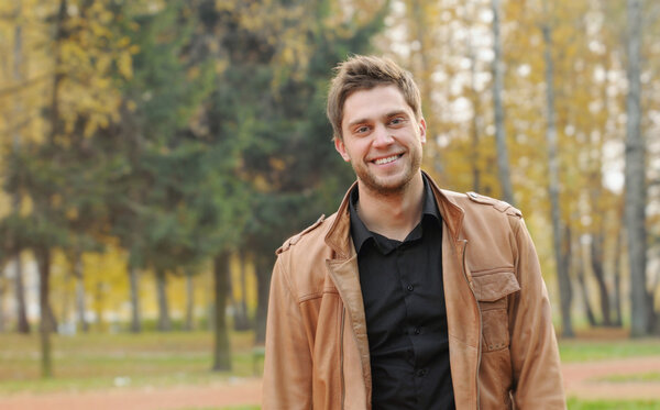 portrait of attractive happy smiling stylish young man in autumn