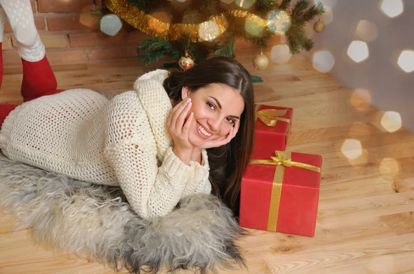 Hermosa joven sonriente con regalos cerca del árbol de Navidad —  Fotos de Stock