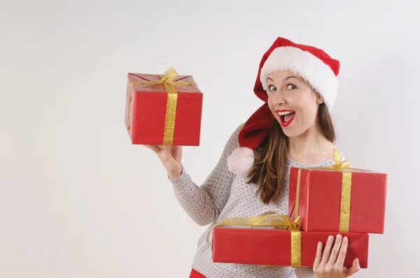 Linda mujer joven emocionante con cajas de regalo en sombrero de santa en whi —  Fotos de Stock