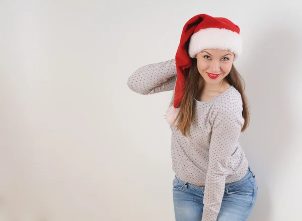 Sorridente giovane donna in cappello di Babbo Natale su sfondo bianco — Foto Stock