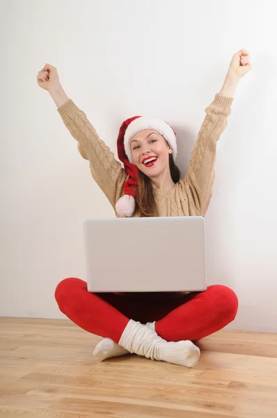Szczęśliwa młoda kobieta w santa hat wyszukiwanie online przedstawia do Chr — Zdjęcie stockowe