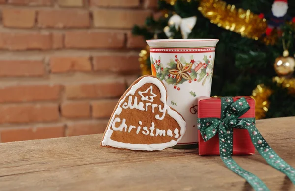 Galleta linda y pequeño regalo con taza de té de cinamon para Navidad —  Fotos de Stock