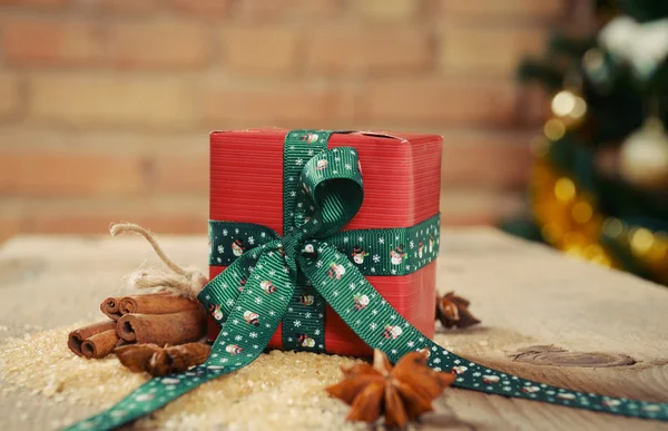 Malý dárek se skořicí na Vánoce na starý dřevěný stůl a r — Stock fotografie