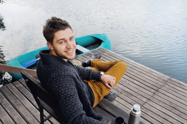 Bonito homem atraente no cais de madeira no lago, estilo de vida — Fotografia de Stock