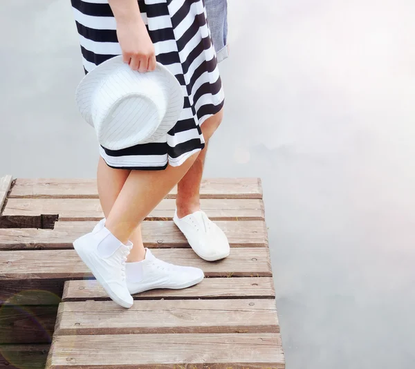 Par av två tonåringar kyssas på pier nära lake i heta summan — Stockfoto