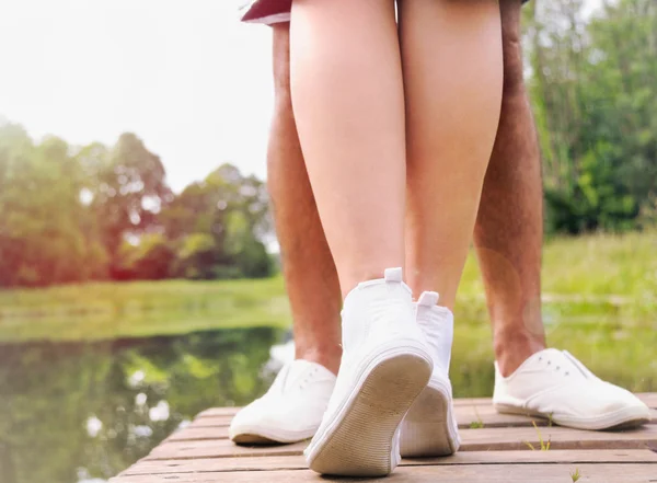 Romantic couple of two teenagers kissing on the pier near lake i — Stock Photo, Image