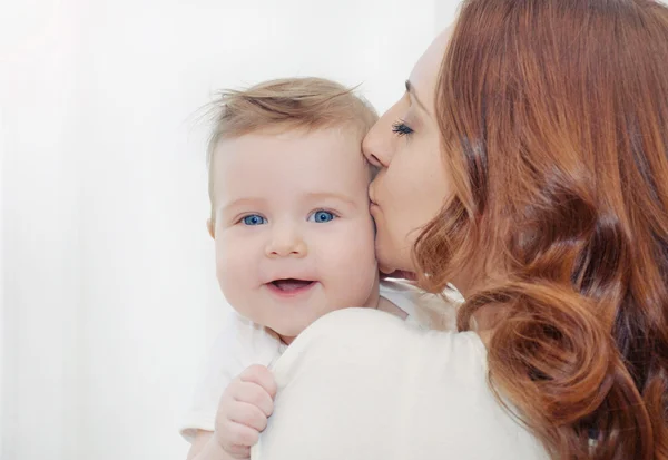 Mãe carinhosa beijando seu bebê bonito feliz menino — Fotografia de Stock