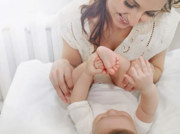 Feliz mãe carinhosa admirar pequenos dedos de seu menino bonito — Fotografia de Stock