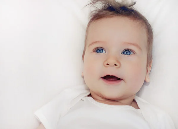 Retrato de lindo bebé feliz niño acostado en pillo blanco suave — Foto de Stock