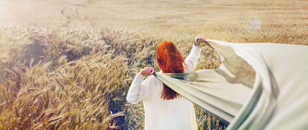 Panoramic picture of walking red hair woman by the plain field, lifestyle travel concept