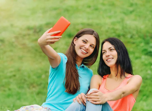 Two women friends smiling and taking pictures of themselves with — Stock Photo, Image