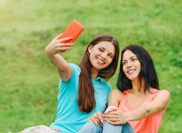 Deux amies souriantes et prenant des photos d'elles avec — Photo