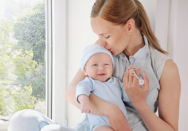 happy caring mother kissing her cute newborn baby boy