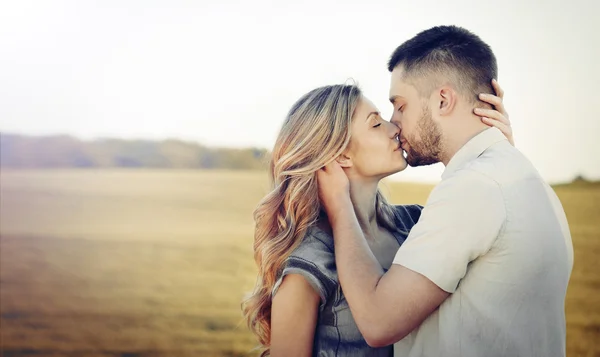 Stunning sensual young couple in love kissing at the sunset in s — Stock Photo, Image