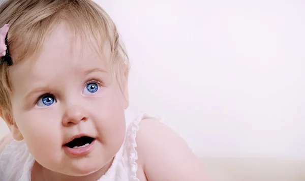 Aranyos érdekelt baba lány, nagy kék szeme portréja — Stock Fotó