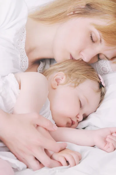 Liten sovande baby flicka med hennes omtänksam mor — Stockfoto