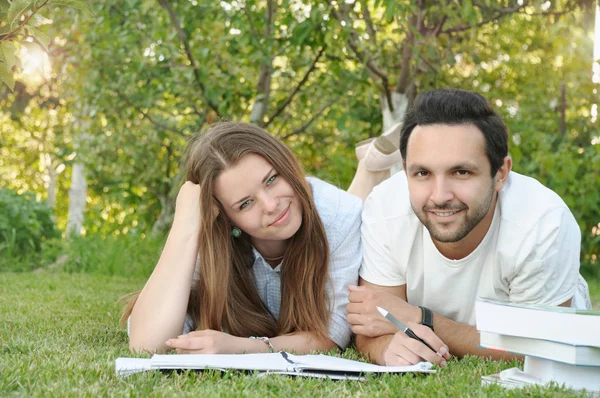 Couple of young students studing in the park by the campus — Stock Photo, Image