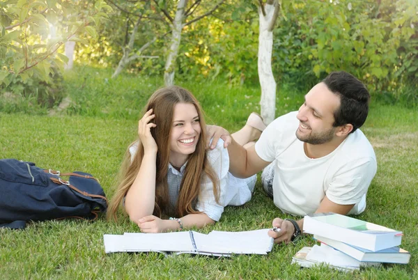 Para młodych studentów baw się podczas studiów w parku — Zdjęcie stockowe