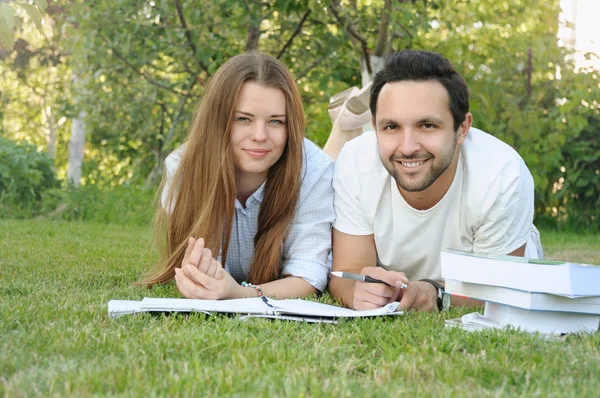 Para młodych studentów studiujących w parku przez kampus — Zdjęcie stockowe