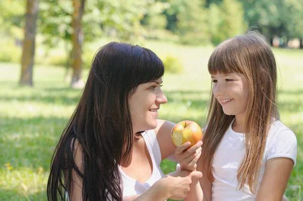 Счастливая девочка и ее мама веселятся на пикнике в парке в Су — стоковое фото
