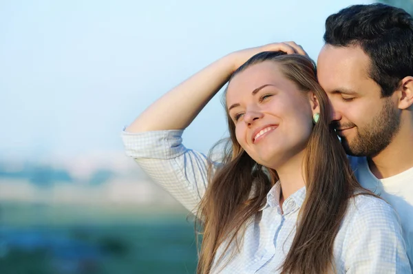 Feliz joven pareja en el amor posando en verano puesta de sol — Foto de Stock