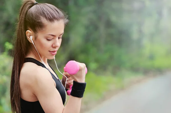 Estilo de vida saludable fitness mujer deportiva con mancuerna y headpho —  Fotos de Stock