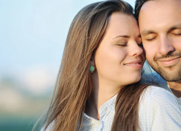 Portrait de jeune couple sensuel posant au coucher du soleil au bord de l'océan — Photo