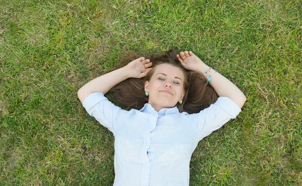 Young cute student having fun on the grass in the park — Stock Photo, Image