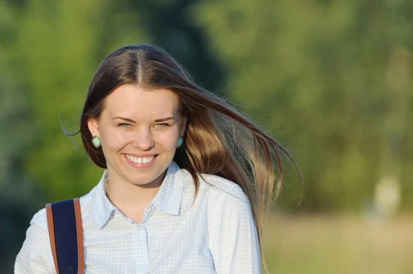 Joven lindo estudiante con bolsa en el parque cerca del campus —  Fotos de Stock