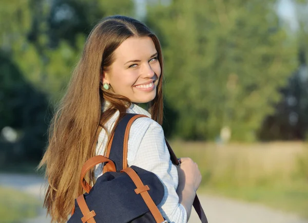 Ung glad student gå med väska i parken — Stockfoto