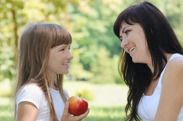 Happy girl and her mother having fun on picnic in the park in su Royalty Free Stock Images